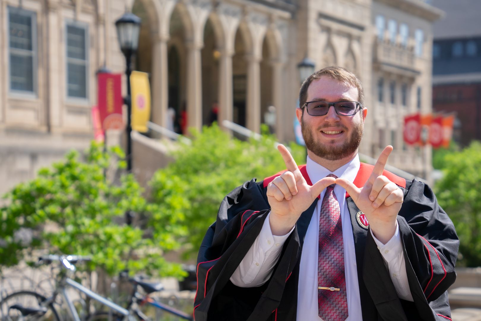 grad making a w with hands in front of the union